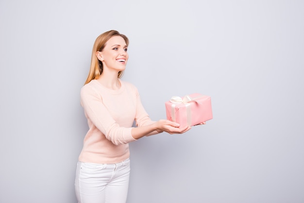 Señora bonita dando caja de regalo aislada en gris