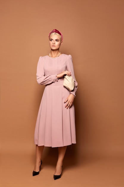 Se ora bonita modelo lleva un lindo vestido rosa con mangas largas