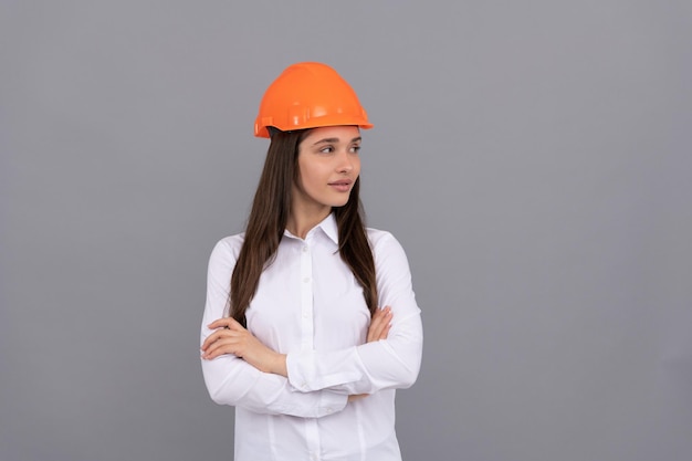 Foto señora confiada en casco de seguridad y camisa blanca cruzó las manos mirando a un lado copia espacio confianza