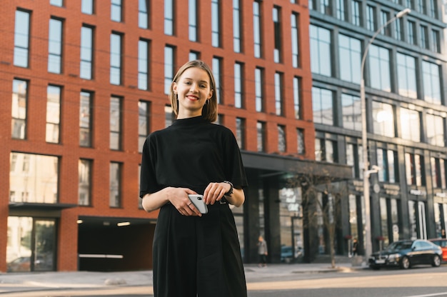 Señora elegante en ropa oscura se opone a la arquitectura moderna