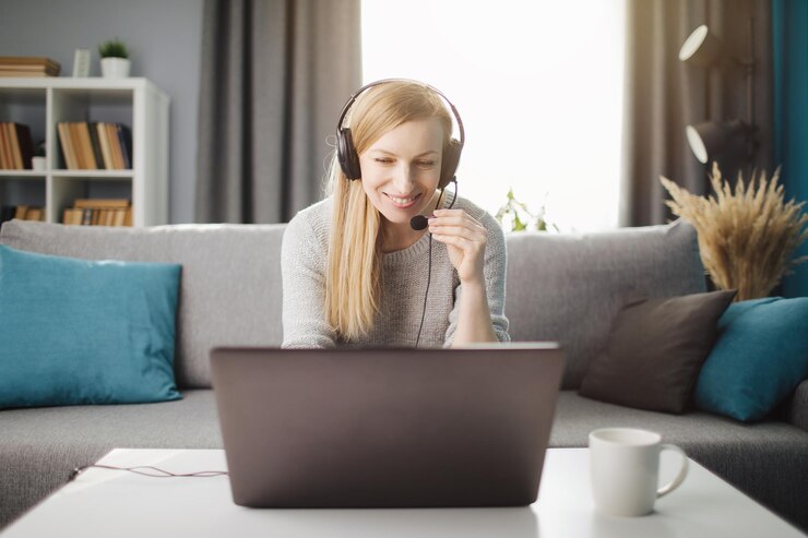 Señora feliz en auriculares con videoconferencia en la computadora portátil