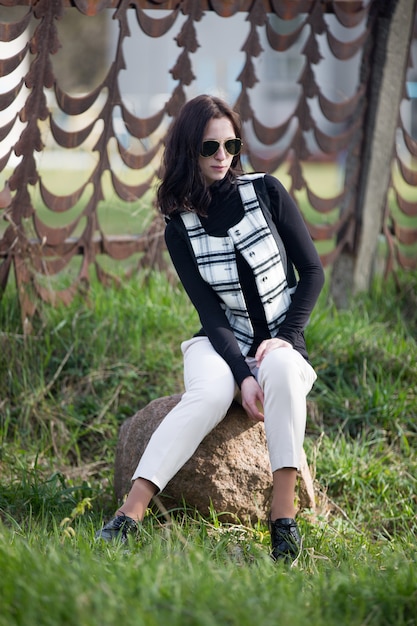 Señora joven en chaqueta y gafas de sol