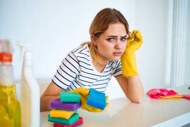 Señora de la limpieza en guantes de goma esponja detergente interior trabajo en casa