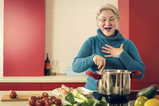 Señora mayor cocinando en casa