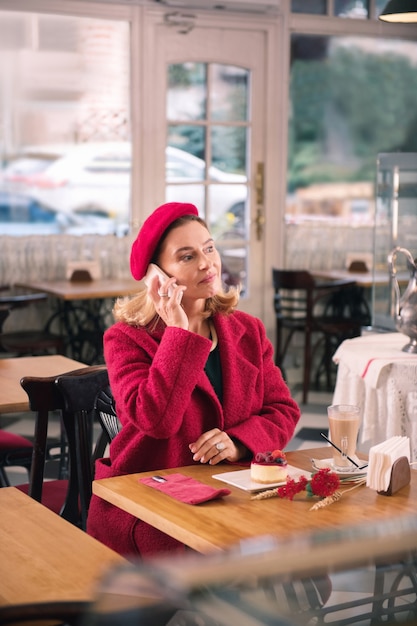 Señora y postre. Elegante dama de moda madura con postre y tomando café en la panadería