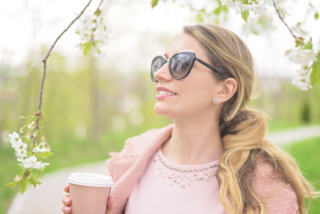 Señora rubia joven que disfruta de tiempo de primavera