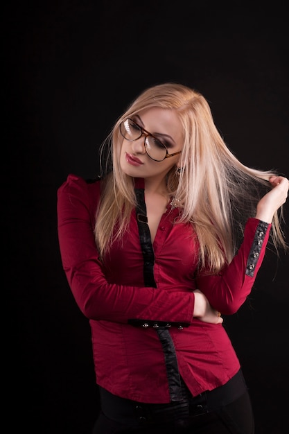 Señora rubia seductora con maquillaje brillante con gafas. Tiro del estudio