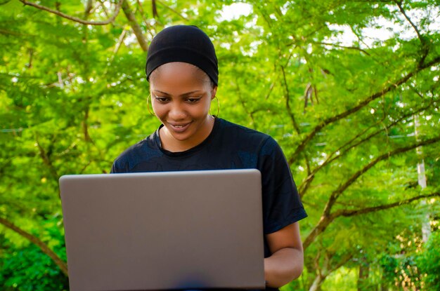 Señora se siente emocionada mientras usa su computadora portátil afuera