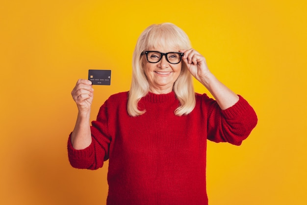 Señora sonriente sosteniendo su tarjeta de crédito