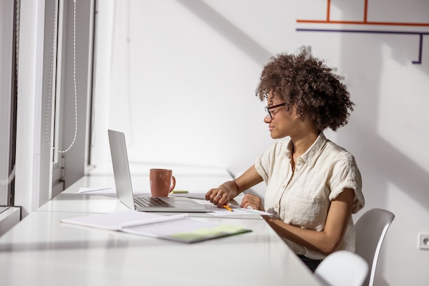 Señora sonriente trabajando con un informe en una oficina moderna