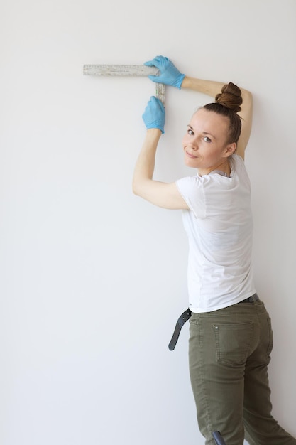 Señorita de entre 30 y 40 años mide la pared para detener algo