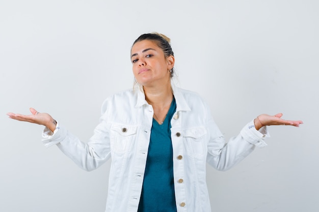 Señorita haciendo gesto de escalas en camisa, chaqueta blanca y mirando seguro de sí mismo. vista frontal.