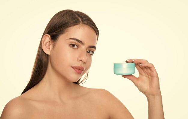 Señorita mostrando tarro de crema para la piel de la cara aislado en blanco con bálsamo hidratante de espacio de copia
