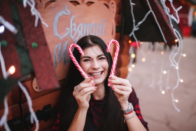 Señorita en vestido de pie cerca de la casa decorada para Navidad