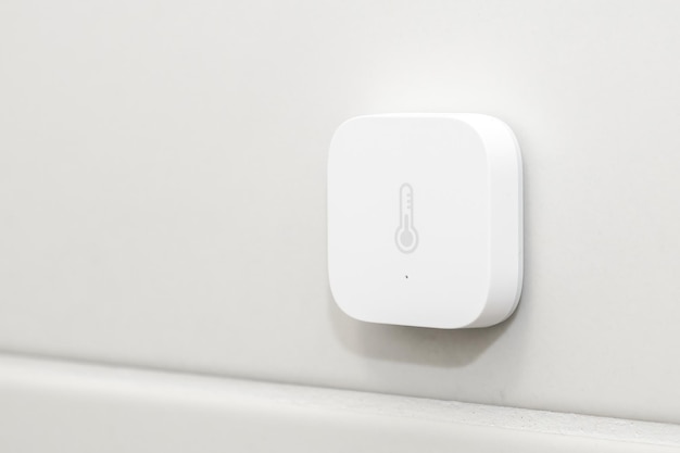 Sensor de calor inteligente en la pared blanca