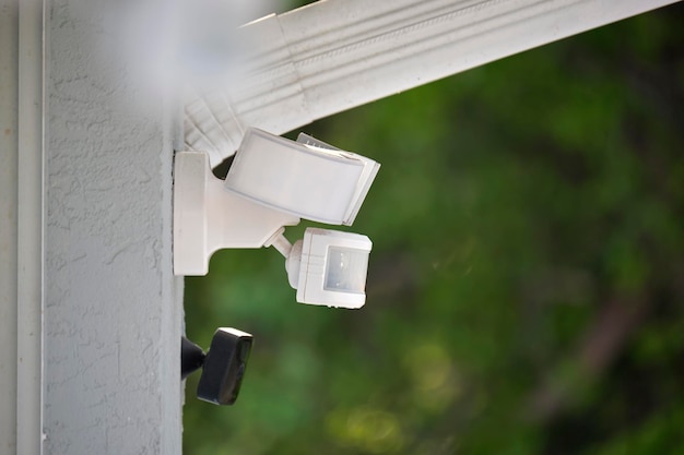 Sensor de movimento com detector de luz montado na parede exterior da casa privada como parte do sistema de segurança