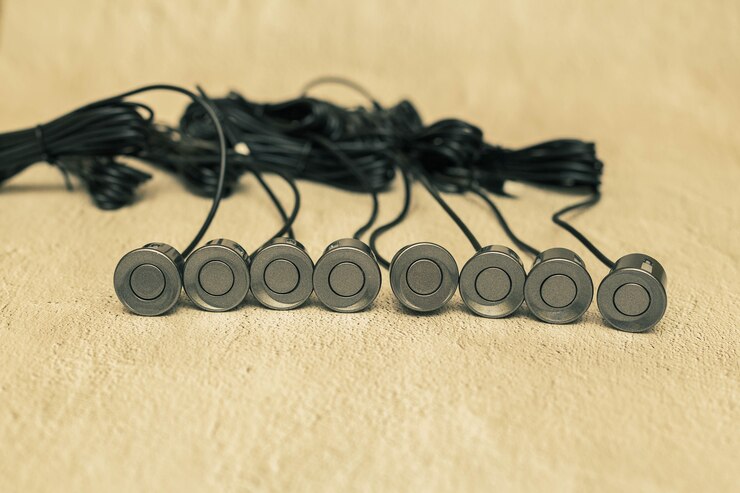 Foto sensores de estacionamiento gris con cables en la superficie de hormigón