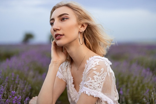 Sensual dama sentada en el campo de lavanda