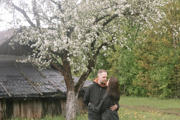 Sensual mujer y hombre en flor de cerezo Pareja enamorada en jardín floreciente en primavera Relación de amor y romance familia feliz al aire libre