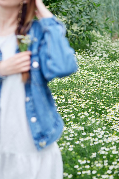 Sensual mujer joven en campo de manzanilla en verano Sensual mujer joven relajante Conexión descuidada con la naturaleza Enfoque selectivo