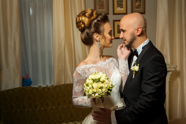 Sensual retrato de la joven pareja de recién casados enamorados abrazándose en trajes de boda