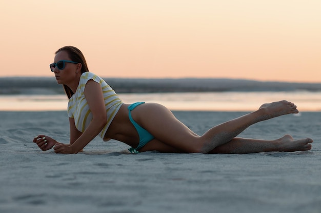 Sensual viajera joven con estilo relajándose en la playa