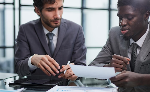 Sentado à mesa com um executivo de empresa negro contratado e assinando um contrato de trabalho