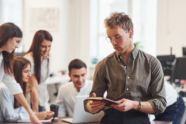 Sentado à mesa. Jovens empresários trabalhando juntos em um escritório moderno.