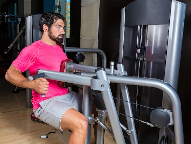 Sentado atrás fila máquina hombre entrenamiento en el gimnasio