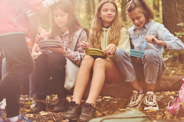 Sentado y descansando Niños en bosque verde durante el día de verano juntos