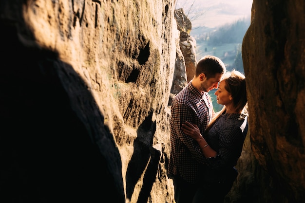 Sentimentales glückliches Paar in Liebesbindung, umgeben von Felsen