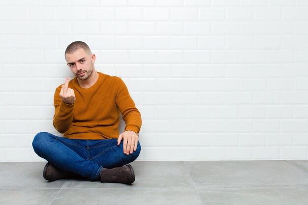 sentindo raiva, irritado, rebelde e agressivo, sacudindo o dedo médio, revidando