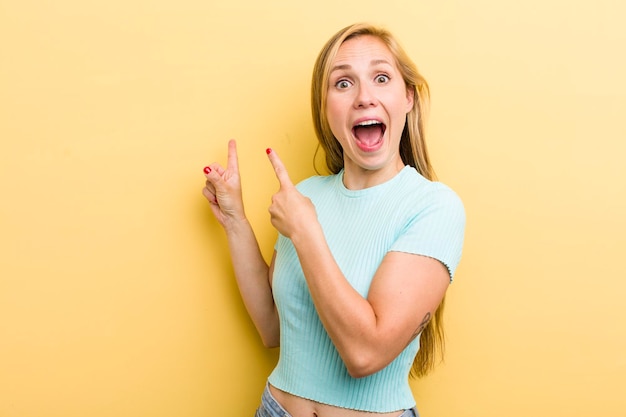 Sentindo-se alegre e surpreso sorrindo com uma expressão chocada e apontando para o lado