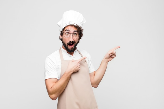 sentindo-se alegre e surpreso, sorrindo com uma expressão chocada e apontando para o lado