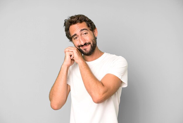 Sentindo-se apaixonado e bonito adorável e feliz sorrindo romanticamente com as mãos ao lado do rosto