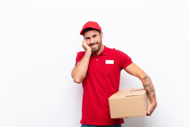 sentindo-se apaixonado e bonito, adorável e feliz, sorrindo romanticamente com as mãos ao lado do rosto