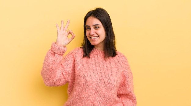 Sentindo-se bem-sucedido e satisfeito sorrindo com a boca aberta fazendo sinal de ok com a mão