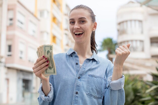 Foto sentindo-se chocado, rindo e comemorando o sucesso do conceito de notas de dólar