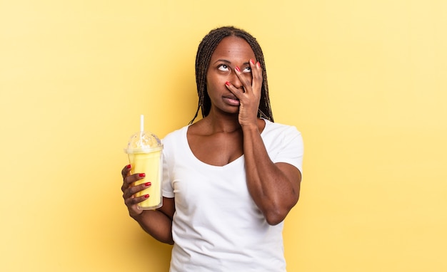 Sentindo-se entediado, frustrado e com sono depois de uma tarefa cansativa, enfadonha e tediosa, segurando o rosto com a mão. conceito de milkshake