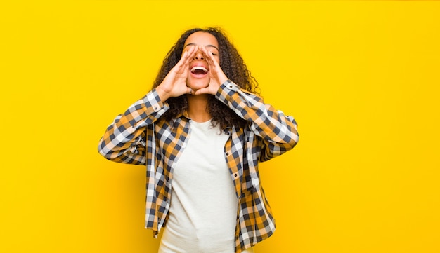 sentindo-se feliz, animado e positivo, dando um grande grito com as mãos ao lado da boca, gritando