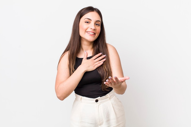 Sentindo-se feliz e apaixonado sorrindo com uma mão ao lado do coração e a outra esticada na frente