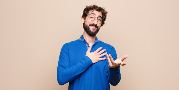 sentindo-se feliz e apaixonado, sorrindo com uma mão ao lado do coração e a outra esticada na frente