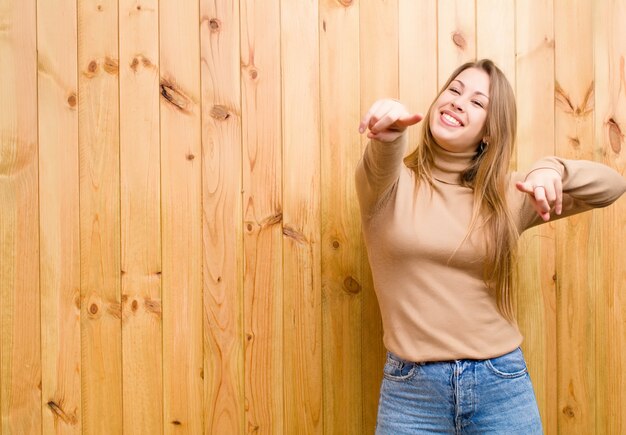 sentindo-se feliz e confiante, apontando com as duas mãos e rindo, escolhendo você