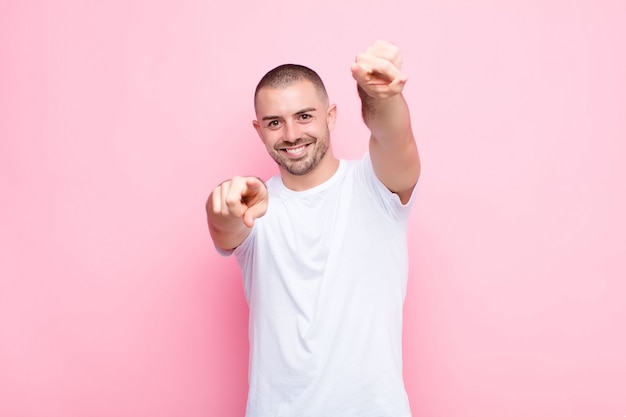 sentindo-se feliz e confiante, apontando com as duas mãos e rindo, escolhendo você