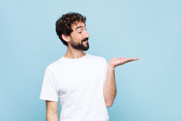 sentindo-se feliz e sorrindo casualmente, olhando para um objeto ou conceito realizado na mão do lado