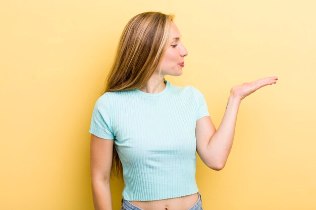 Sentindo-se feliz e sorrindo casualmente olhando para um objeto ou conceito segurado na mão ao lado