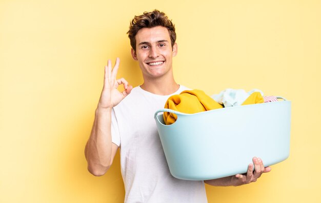 Sentindo-se feliz, relaxado e satisfeito, mostrando aprovação com gesto bem, sorrindo. conceito de lavagem de roupas