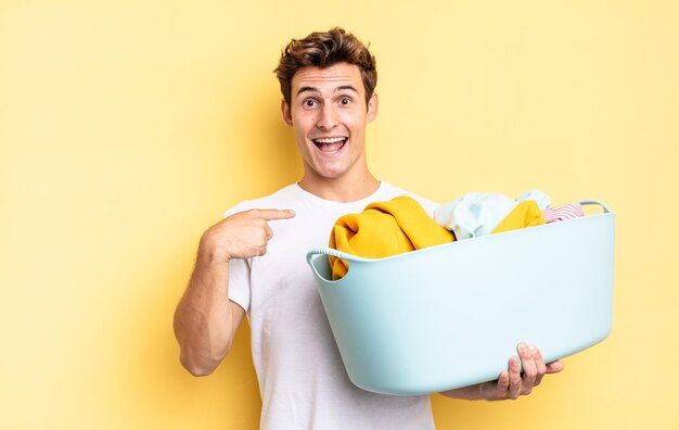 Sentindo-se feliz, surpreso e orgulhoso, apontando para si mesmo com um olhar animado e espantado. conceito de lavagem de roupas