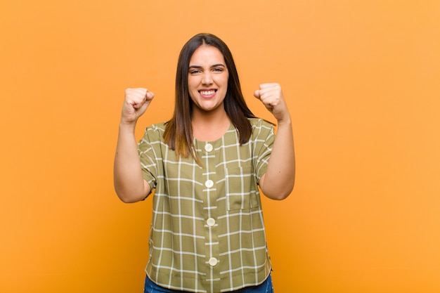 sentindo-se feliz, surpreso e orgulhoso, gritando e comemorando o sucesso com um grande sorriso