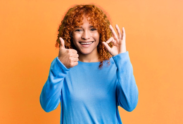 Sentindo-se feliz, surpreso, satisfeito e surpreso, mostrando gestos bem e polegares para cima sorrindo